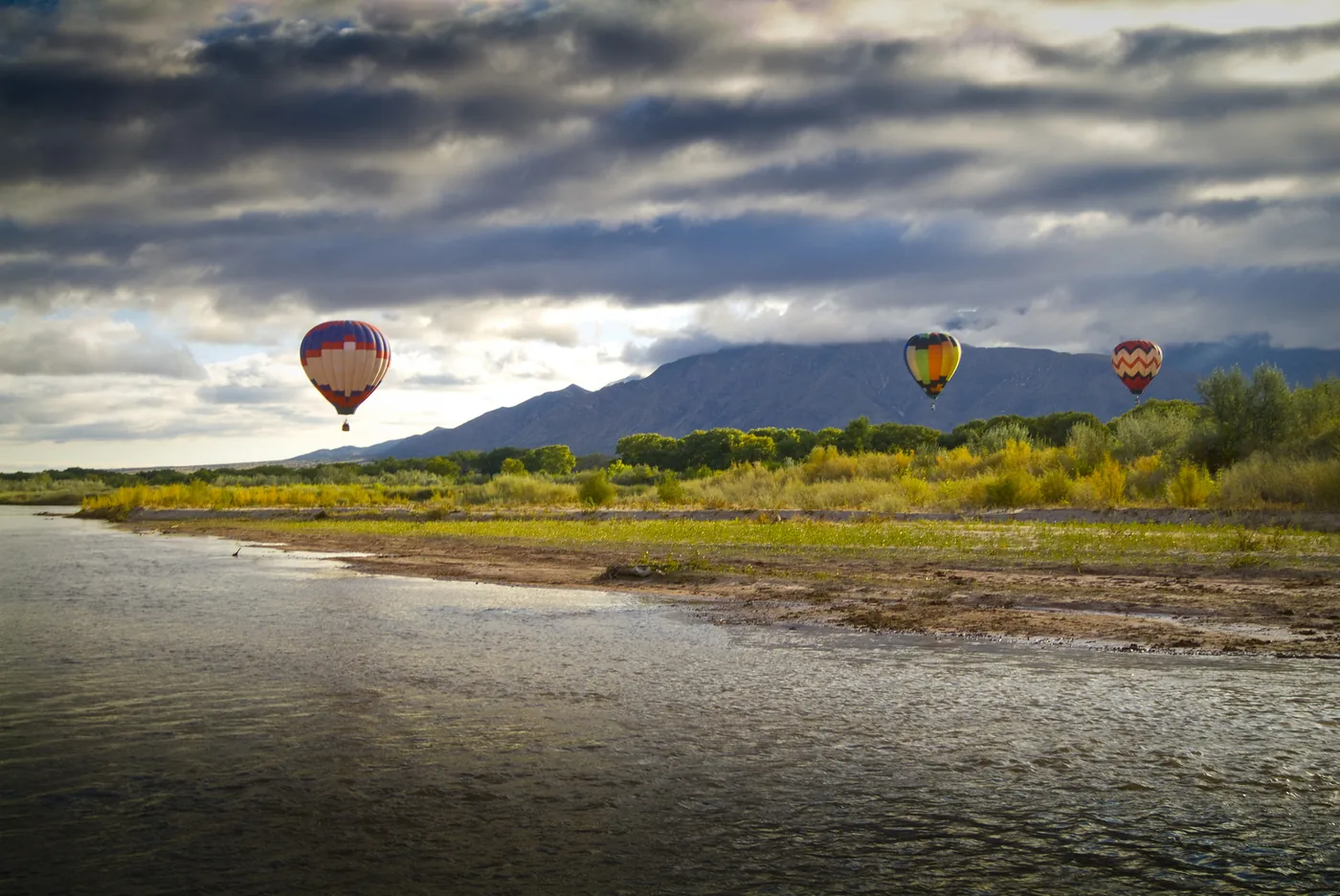 Hot air balloons over a river valley in New Mexico